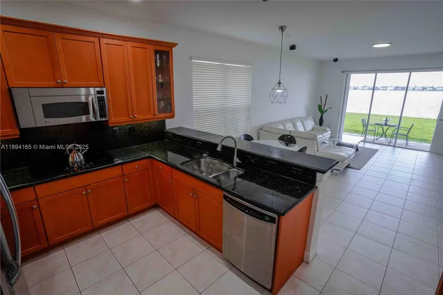 a kitchen with stainless steel appliances granite countertop a stove a sink and a microwave