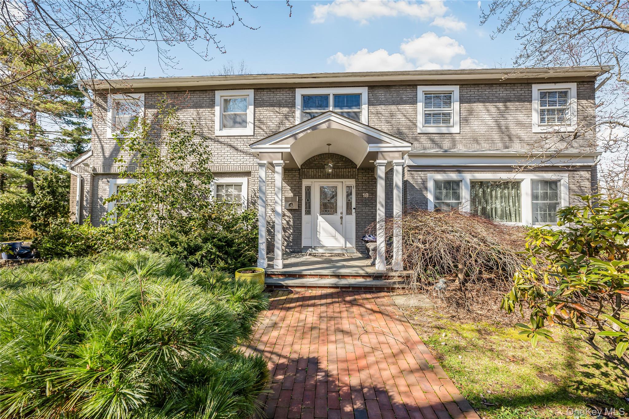 18 Woodland Road Roslyn, NY 11576 - Photo 1 of 21 front view of a house with a yard