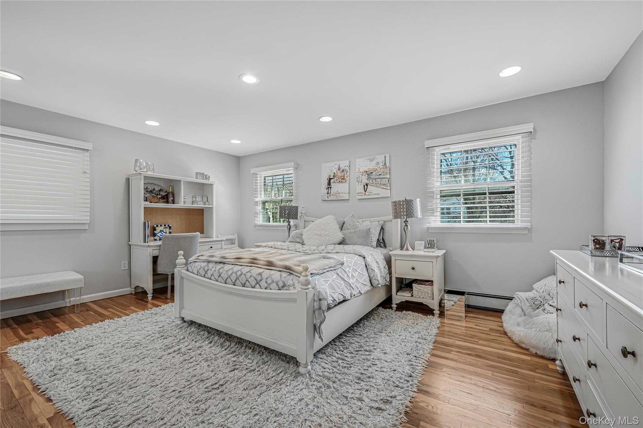 18 Woodland Road Roslyn, NY 11576 - Photo 9 of 21 a spacious bedroom with a bed and wooden floor