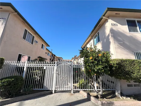 a view of a street with brick wall and plants