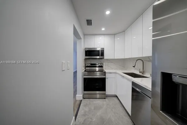 a kitchen with stainless steel appliances granite countertop a stove and a refrigerator