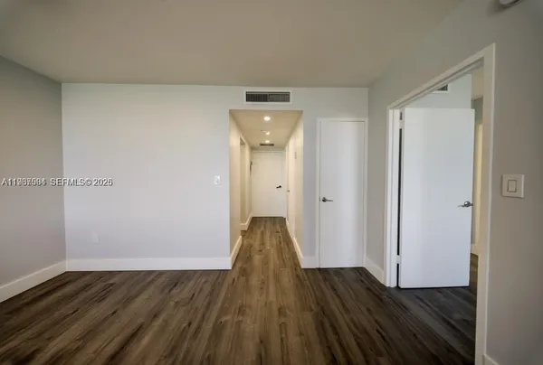 a view of a room with wooden floor and white doors