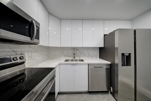 a kitchen with a stove sink and refrigerator