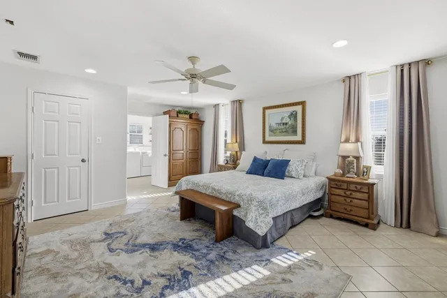 a spacious bedroom with a large bed and a chandelier