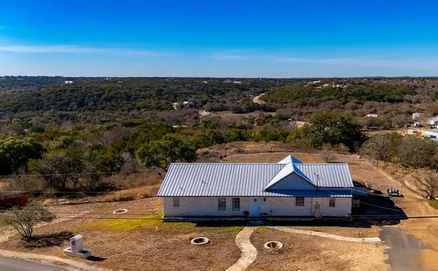 an aerial view of a house with a yard and lake view