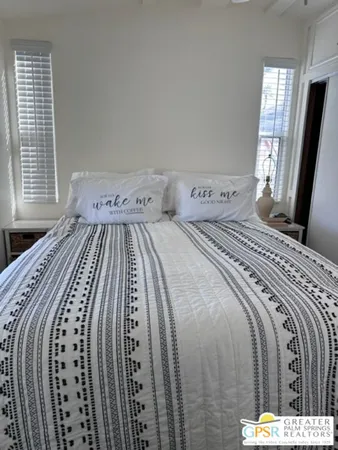 a bedroom with a bed next to a window