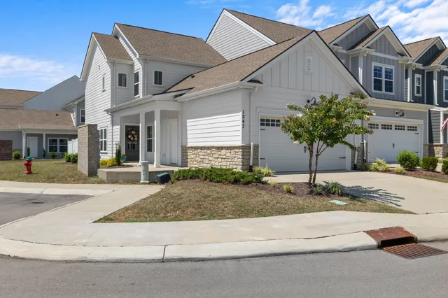 a front view of a house with garage and plants