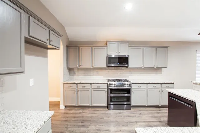 a kitchen with a sink stove and cabinets