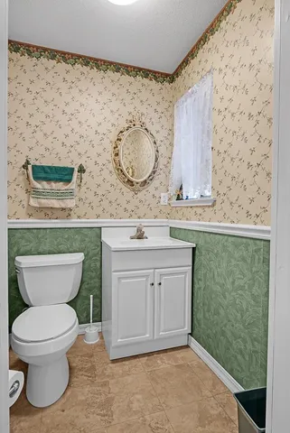 a bathroom with a toilet sink and mirror
