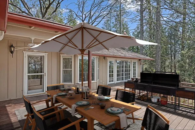 a view of a house with backyard and wooden deck