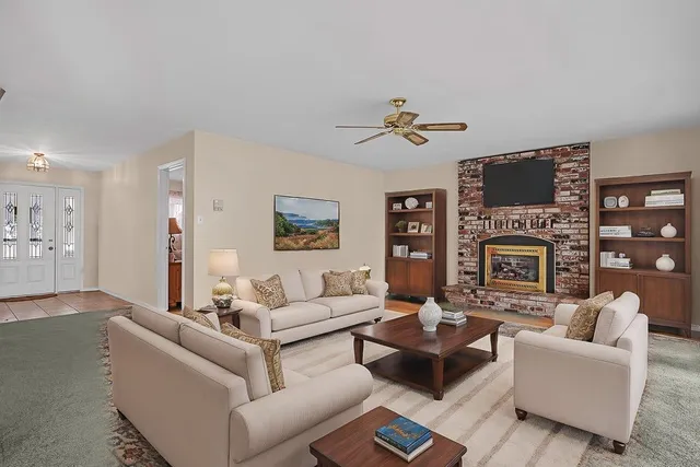 a living room with furniture a fireplace and a flat screen tv