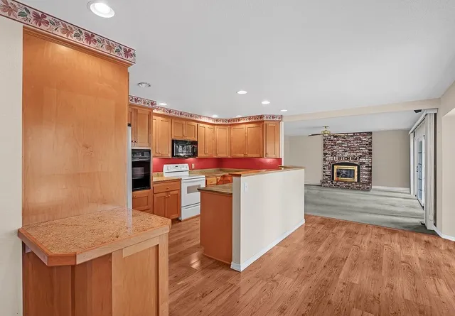 a kitchen with stainless steel appliances kitchen island granite countertop a refrigerator and a stove top oven