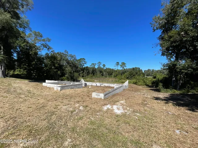a view of a yard with trees in the background