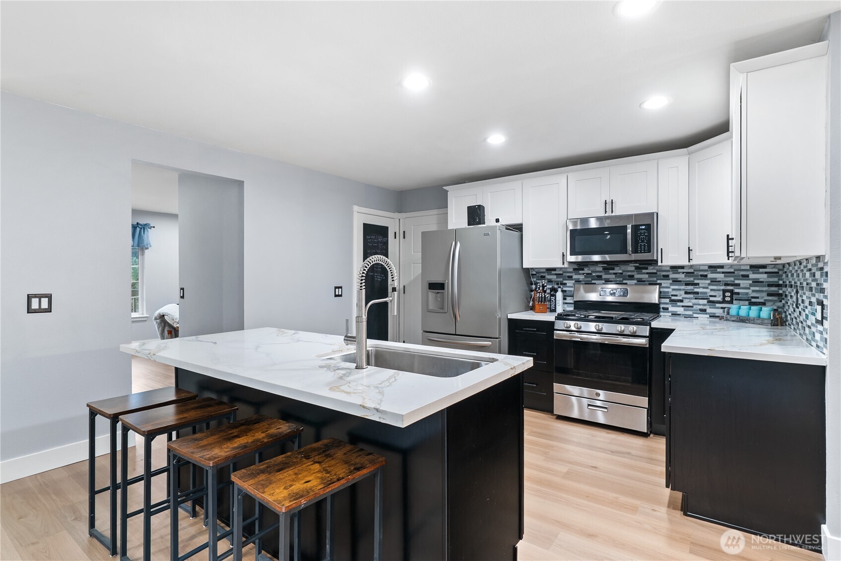 a kitchen with appliances cabinets and wooden floor