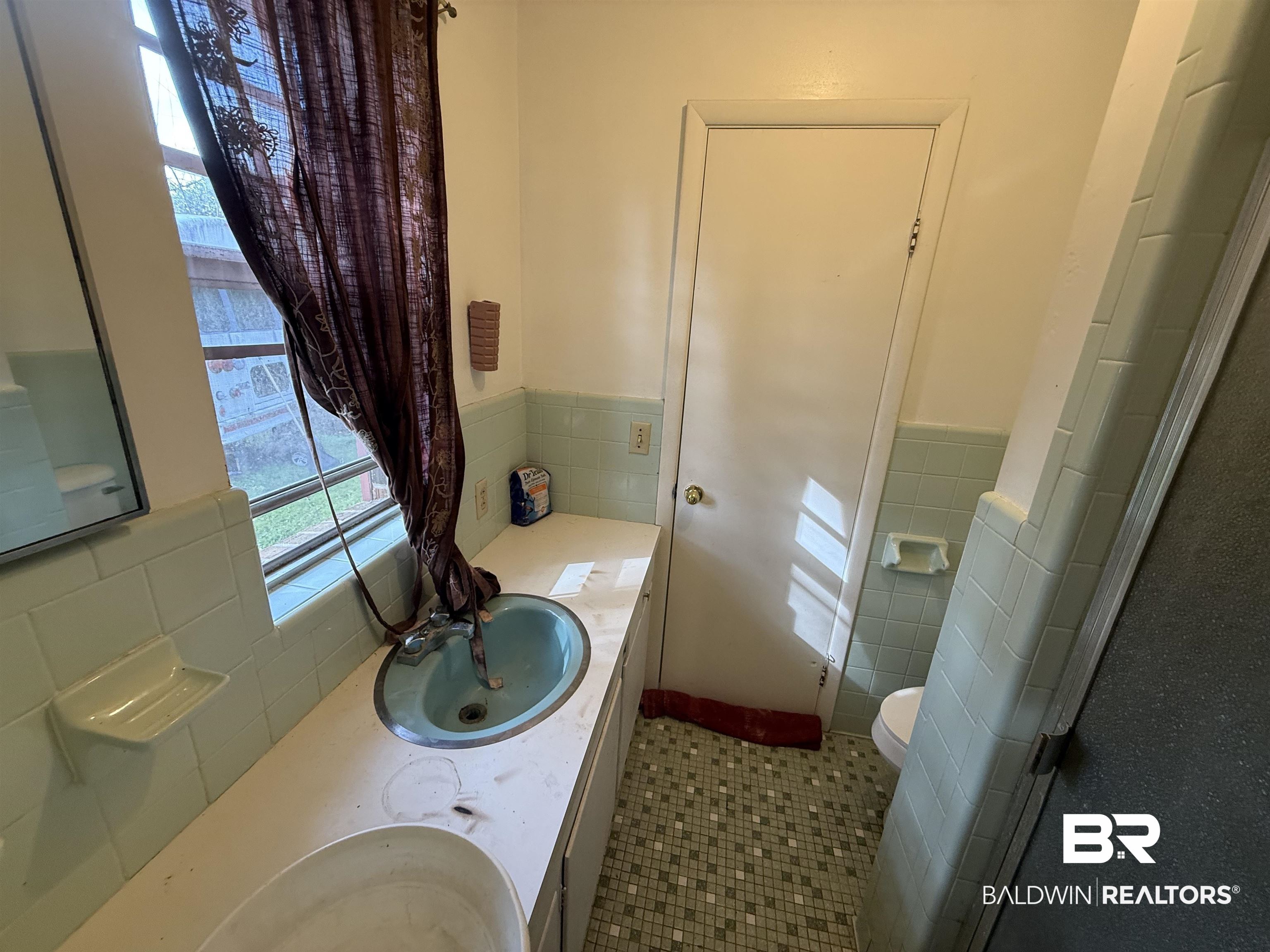 2807 Pea Ridge Road Brewton, AL 36426 - Photo 8 of 12 Bathroom featuring vanity, tile walls, a wainscoted wall, and tile patterned flooring