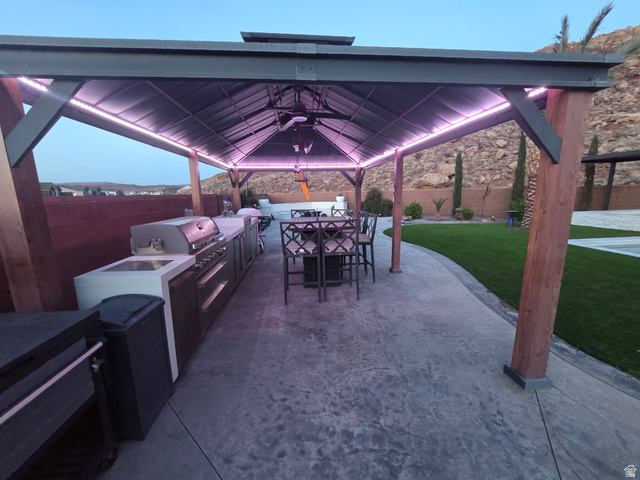 6105 Bunda Way St. George, UT 84790 - Photo 42 of 49 Expansive outdoor living area featuring a covered patio with integrated lighting, a ceiling fan, and substantial wood support pillars
