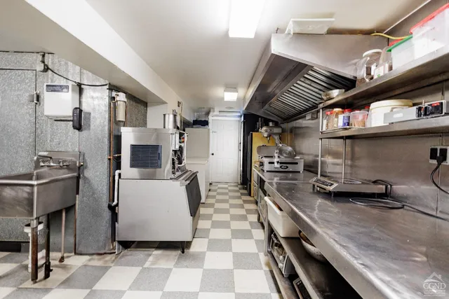 a kitchen with stainless steel appliances a sink a stove a refrigerator and cabinets