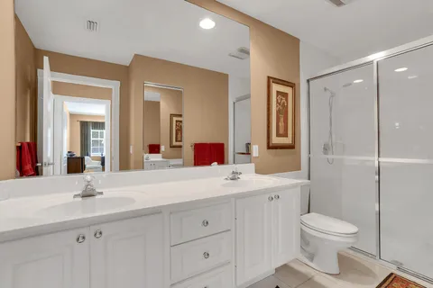 a bathroom with a toilet a sink a mirror and a shower