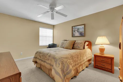 a spacious bedroom with a bed and a lamp