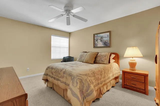 a spacious bedroom with a bed and a lamp