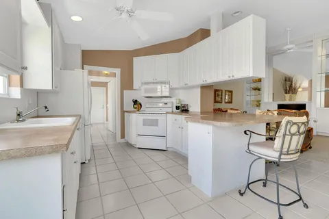 a kitchen with cabinets and chairs