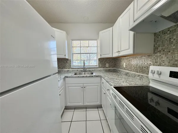 a kitchen with a sink stove and cabinets