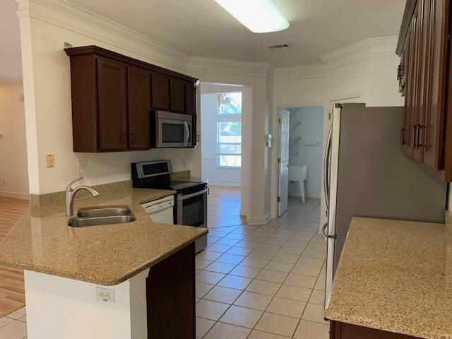 136 Gail La Rue Fort Walton Beach, FL 32547 - Photo 8 of 31 a kitchen with a sink a microwave a refrigerator and cabinets