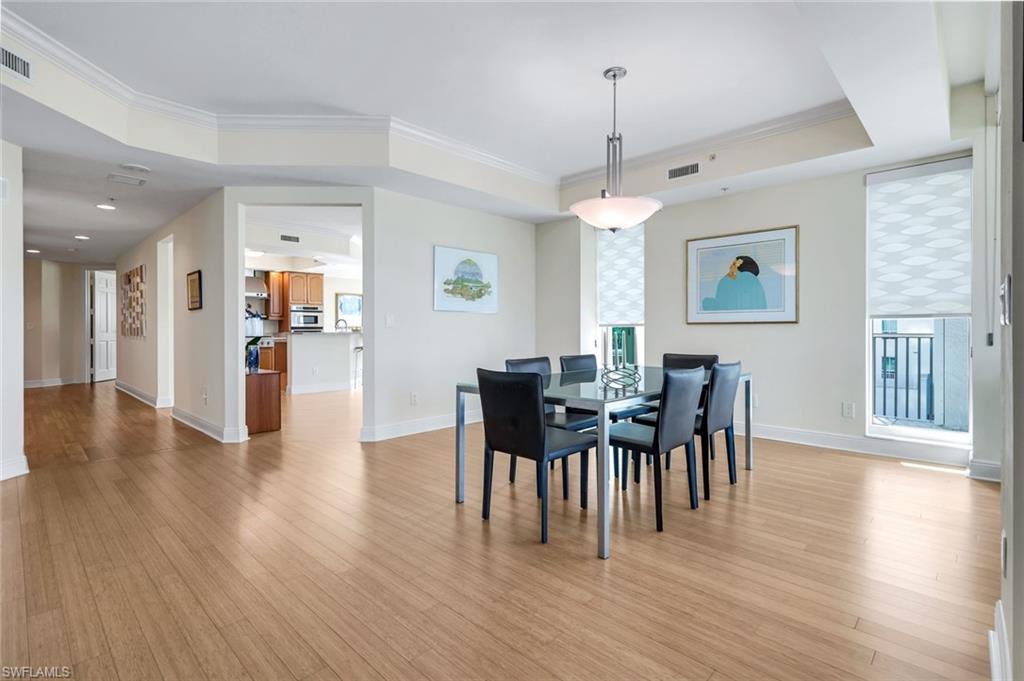 285 Grande Way, Unit 401 Naples, FL 34110 - Photo 13 of 50 a view of a dining room with furniture and wooden floor
