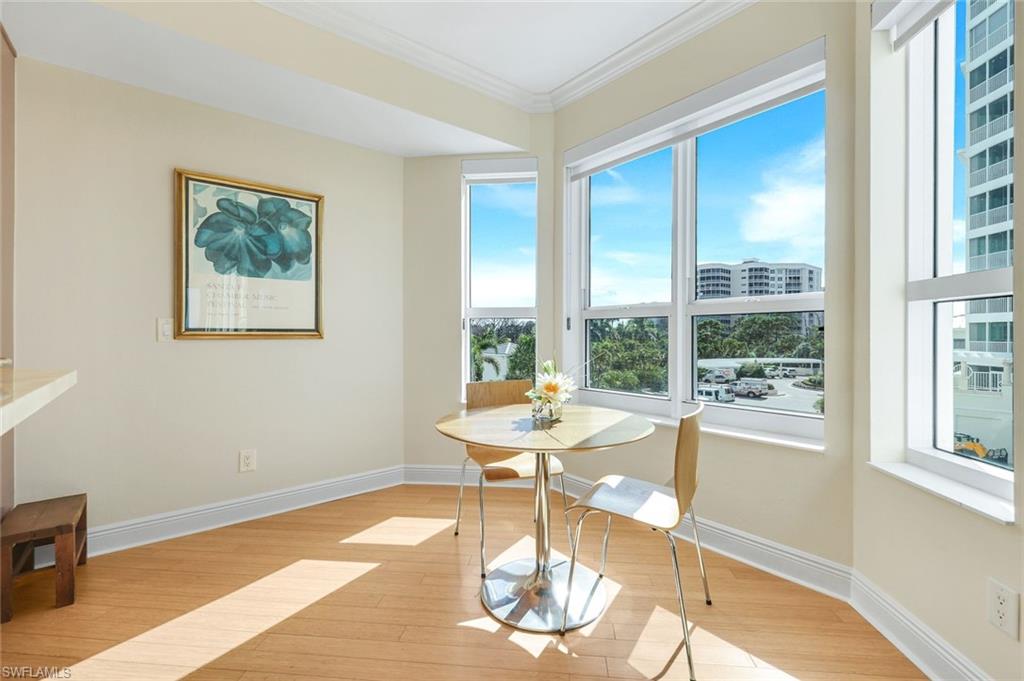 285 Grande Way, Unit 401 Naples, FL 34110 - Photo 18 of 50 a dining room with wooden floor and a table