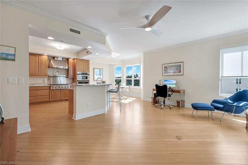 285 Grande Way, Unit 401 Naples, FL 34110 - Photo 19 of 50 a living room with furniture and kitchen view with wooden floor