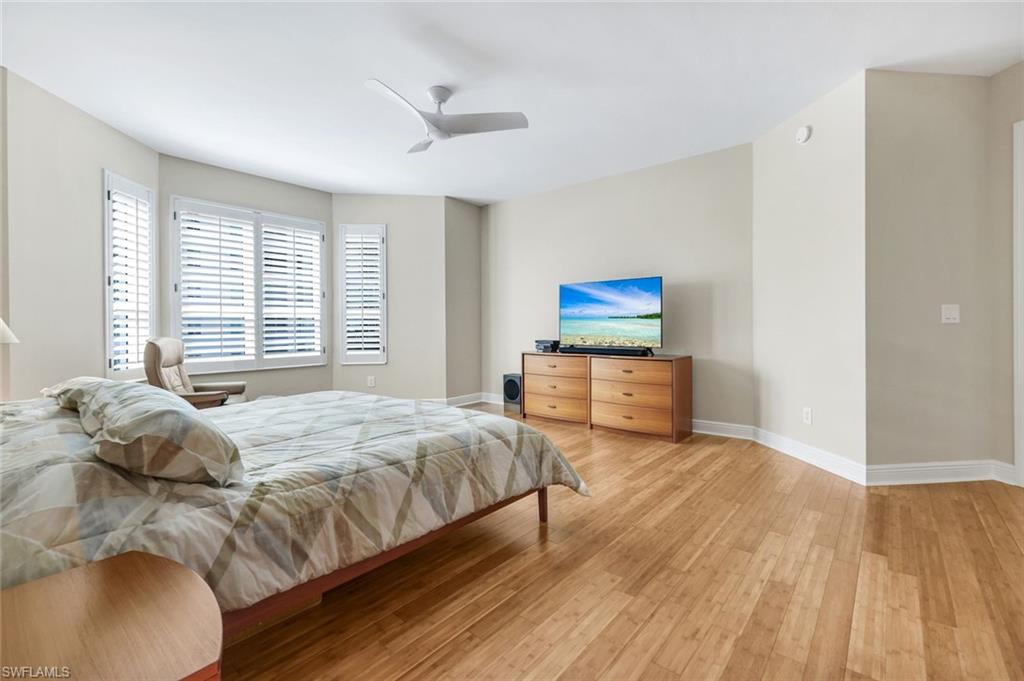 285 Grande Way, Unit 401 Naples, FL 34110 - Photo 23 of 50 a bedroom with a bed and wooden floor