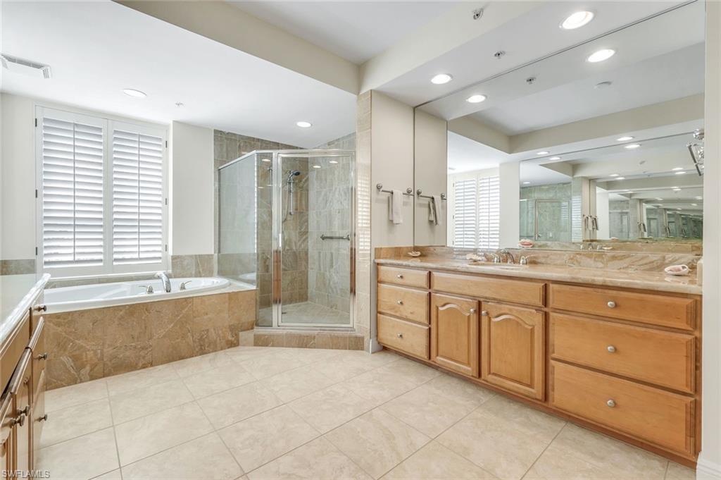285 Grande Way, Unit 401 Naples, FL 34110 - Photo 26 of 50 a large spacious bathroom with a granite countertop tub sink shower and mirror