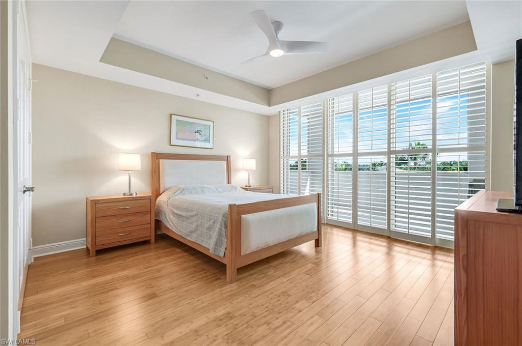 285 Grande Way, Unit 401 Naples, FL 34110 - Photo 27 of 50 a bedroom with a large bed and a large window