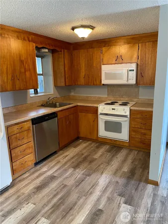 a kitchen with stainless steel appliances granite countertop a stove a sink and a microwave