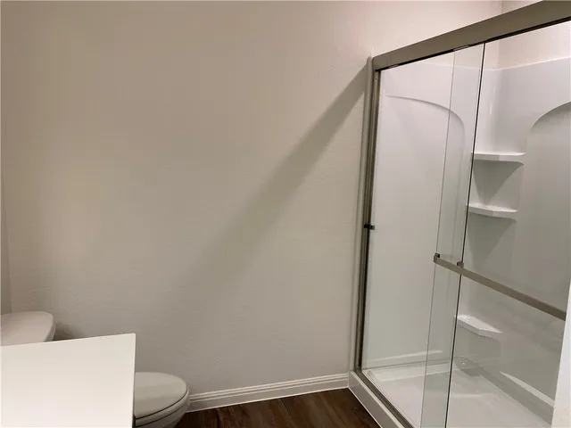 a large kitchen with stainless steel appliances granite countertop a stove top oven a sink and dishwasher with wooden floor