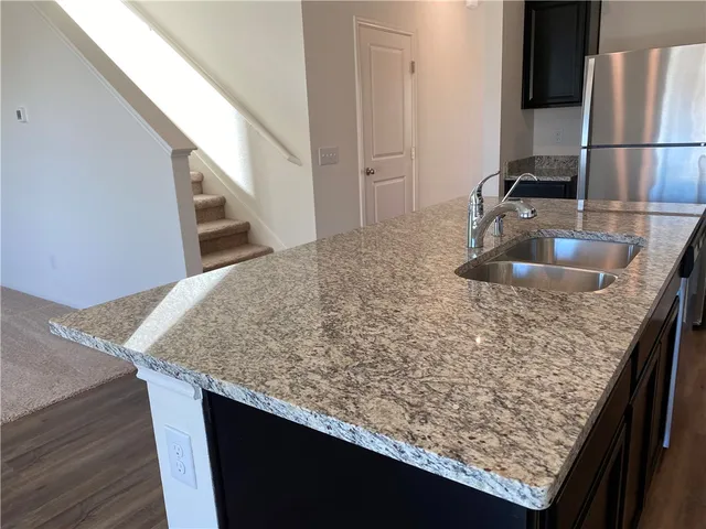 a kitchen with stainless steel appliances granite countertop wooden cabinets a stove top oven a sink and dishwasher