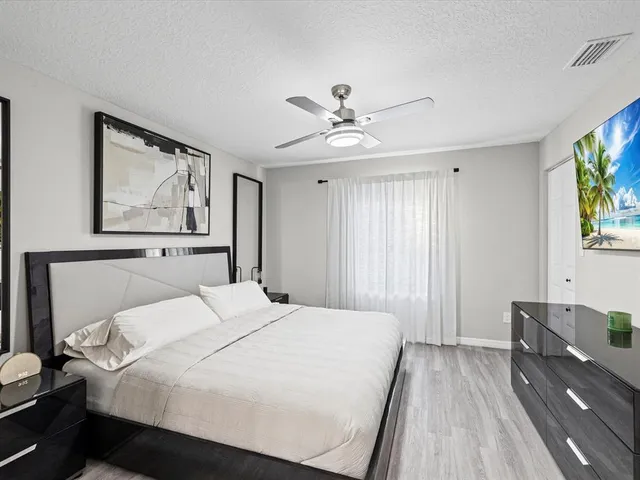 a bedroom with a large bed and a chandelier