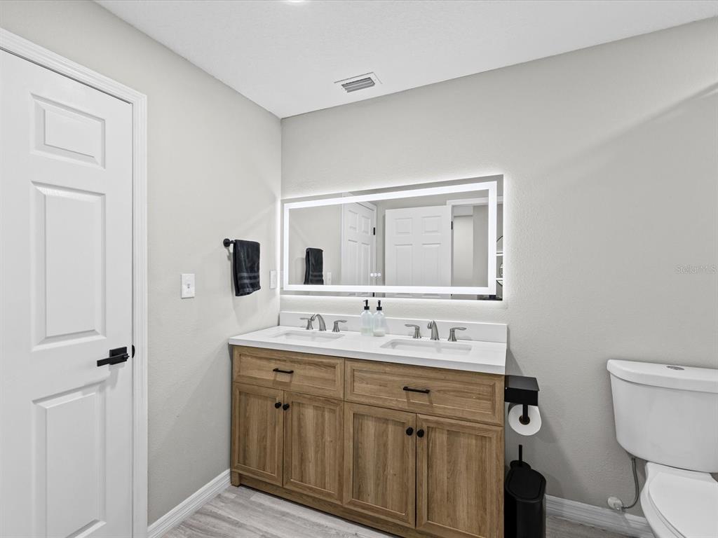 4367 Har Paul Circle Tampa, FL 33614 - Photo 19 of 31 a bathroom with a double vanity sink toilet and mirror