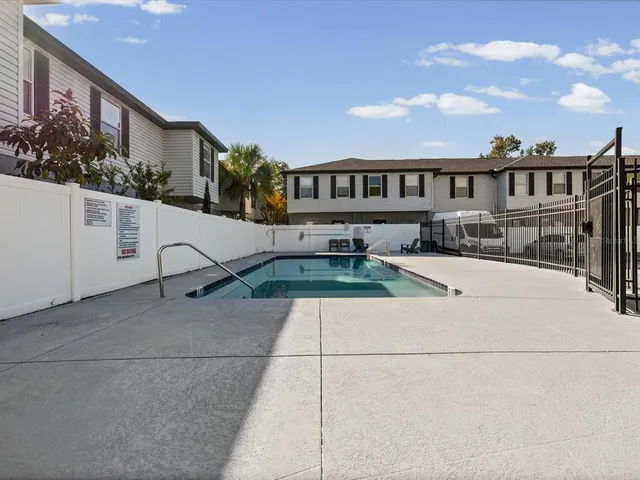 a view of a house with backyard and sitting area