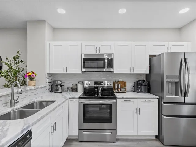 a kitchen with white cabinets and stainless steel appliances