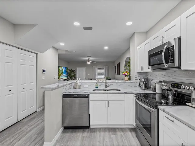 a kitchen with stainless steel appliances granite countertop a sink and stove top oven