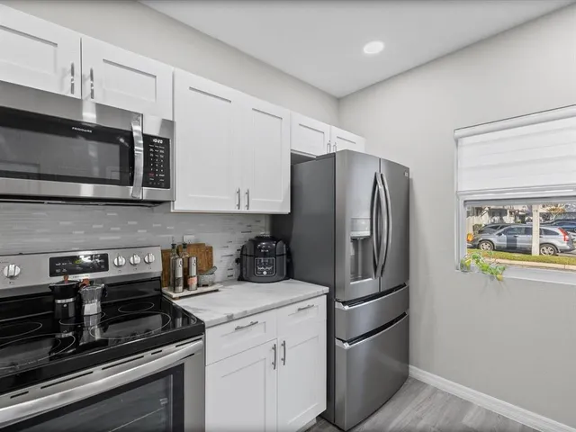 a kitchen with stainless steel appliances granite countertop a refrigerator microwave and sink