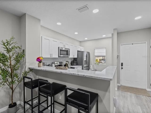a kitchen with granite countertop a table chairs stove and cabinets