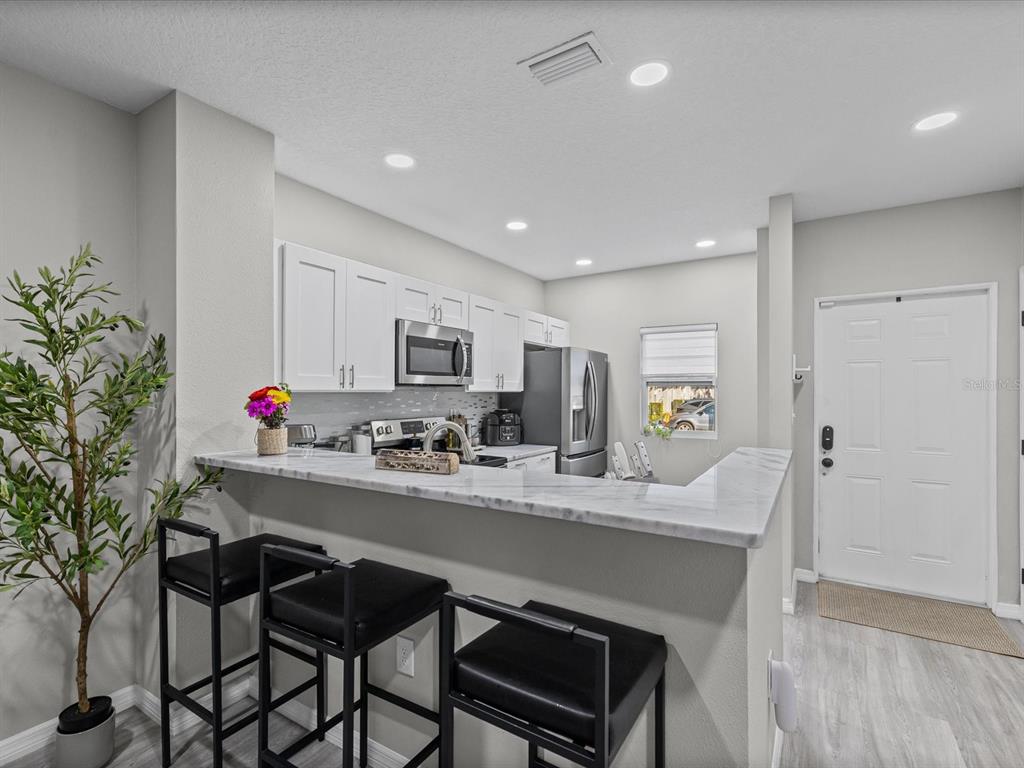 4367 Har Paul Circle Tampa, FL 33614 - Photo 7 of 31 a kitchen with granite countertop a table chairs stove and cabinets