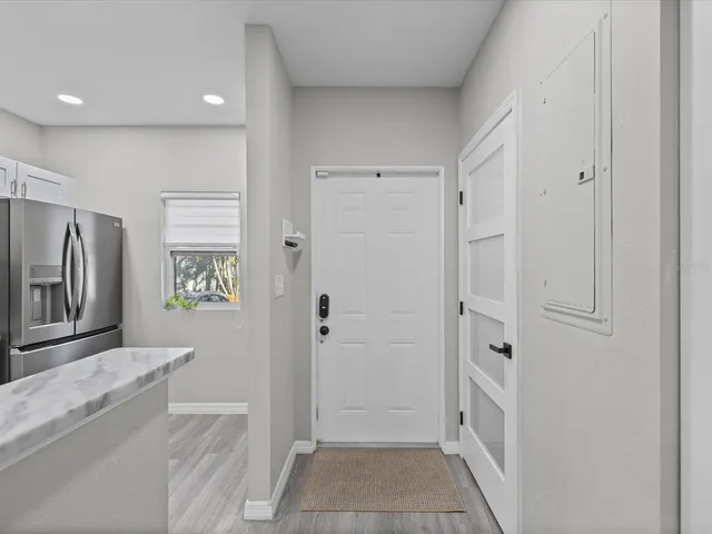 a view of a hallway with a refrigerator and a sink