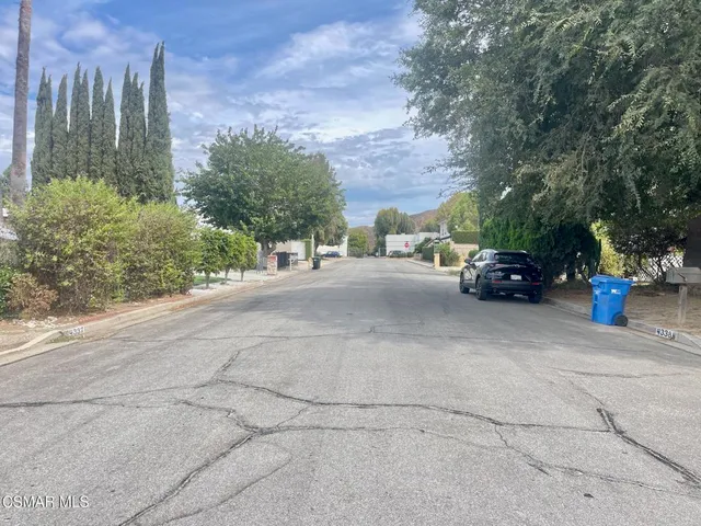 a view of a street with cars parked
