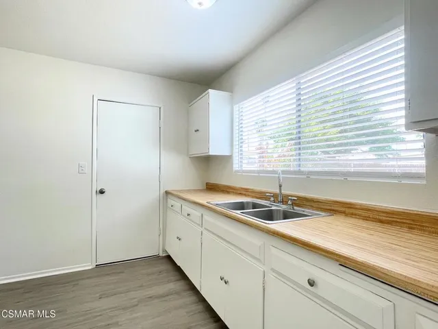 a kitchen with granite countertop cabinets sink and a window