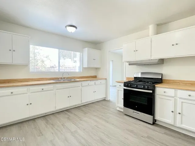 a kitchen with granite countertop white cabinets and appliances