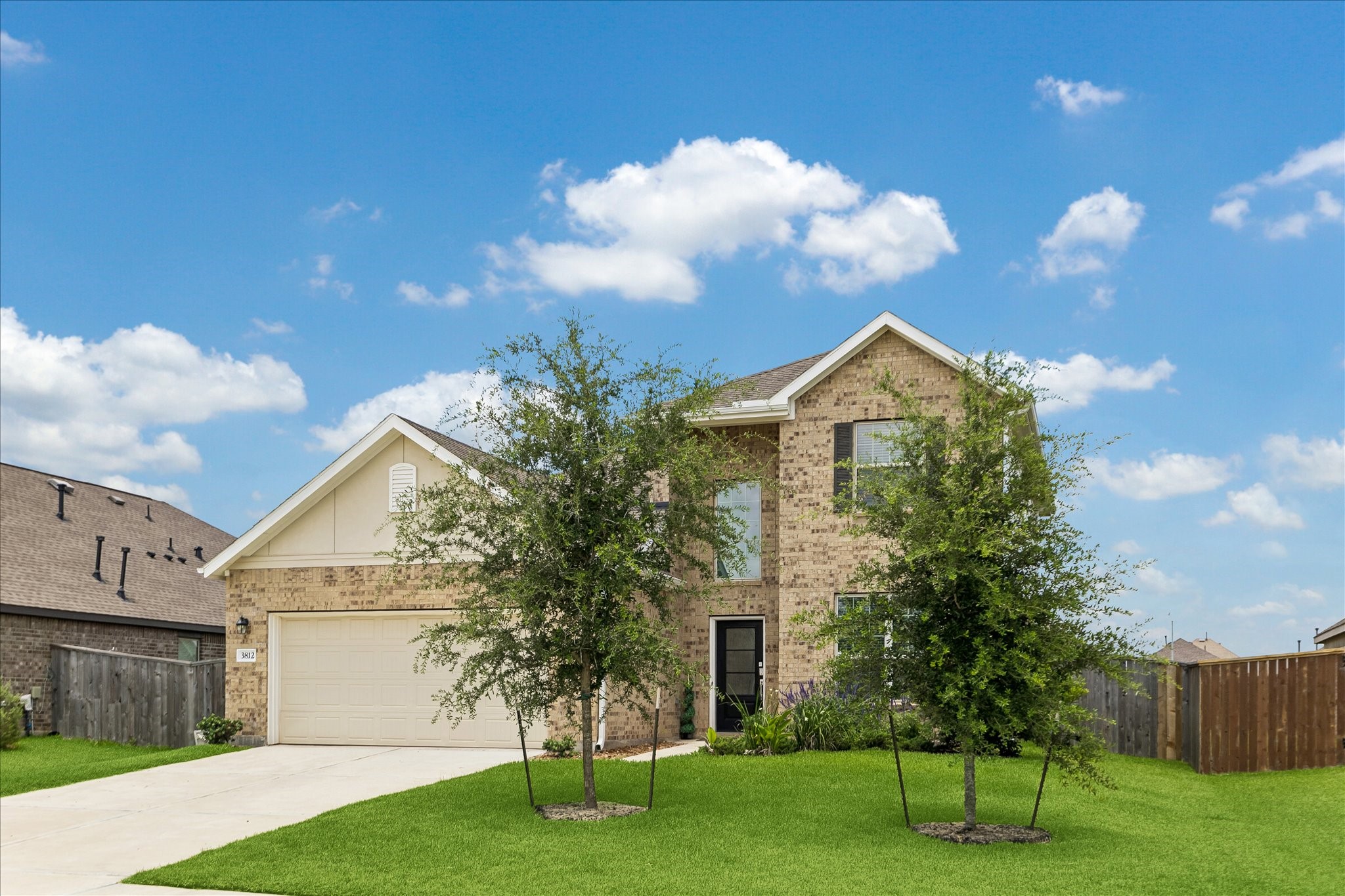 3812 Moss Hl Road Rosenberg, TX 77469 - Photo 6 of 20 Charming two-story brick home with a spacious front lawn, two-car garage, and a neatly paved driveway. The exterior features mature trees and a well-maintained landscape.