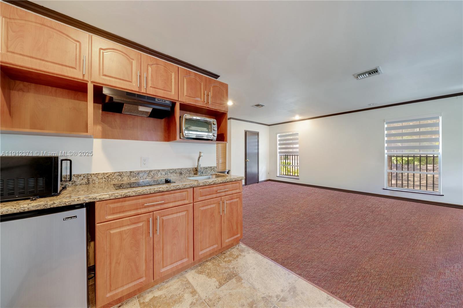 2997 Day Avenue Miami, FL 33133 - Photo 6 of 15 a kitchen with granite countertop a sink stove and cabinets